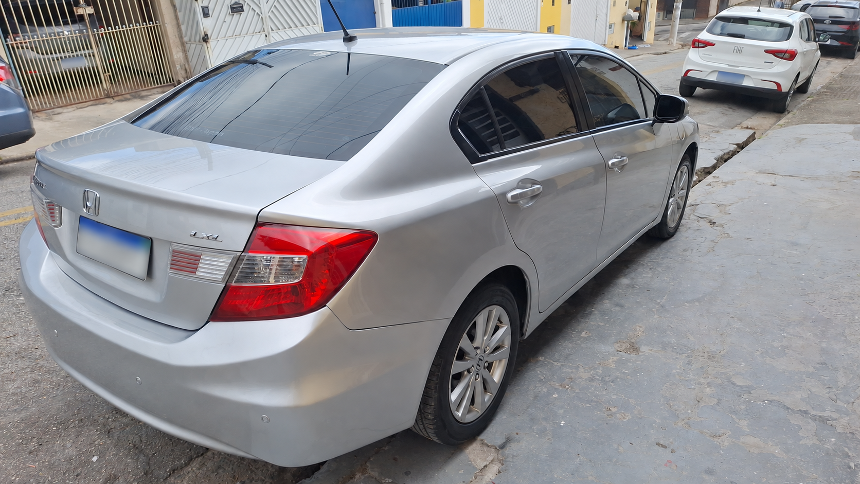 Honda Civic prata visto de trás pelo lado do motorista, com pintura restaurada