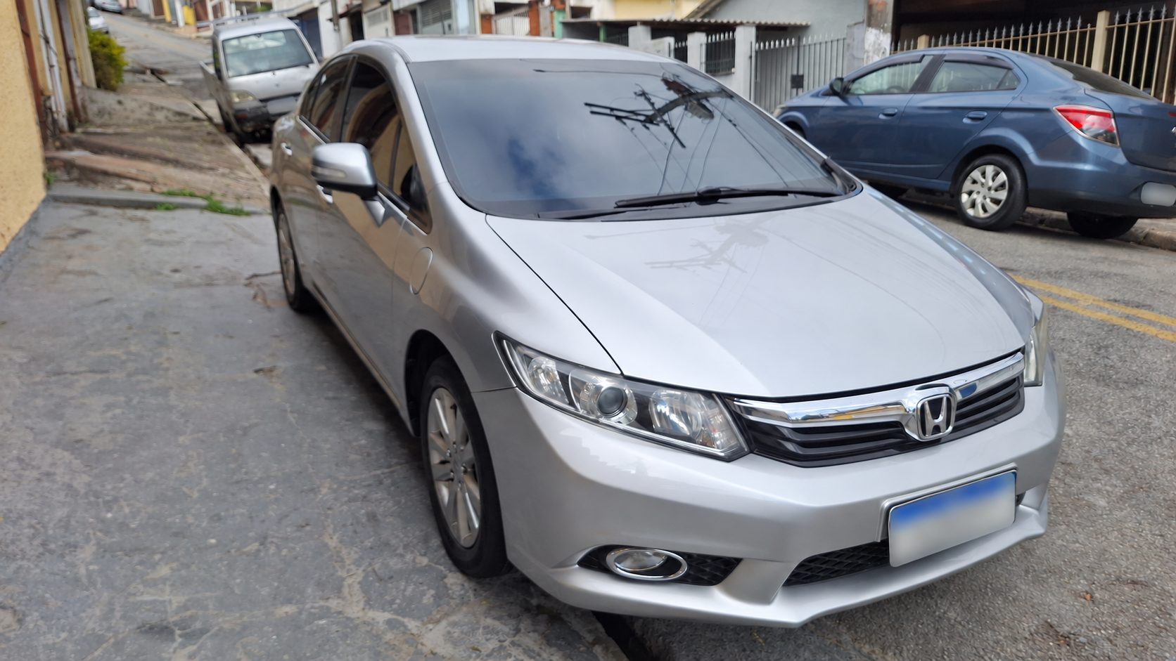 Honda Civic prata visto de frente e de lado após os cuidados da oficina